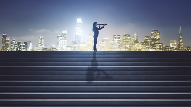 sideviewofbusinesswomanwithtelescopeontopofconcrete