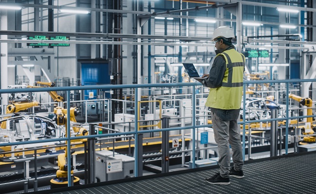 carfactoryengineerinhighvisibilityvestusinglaptopcomputer