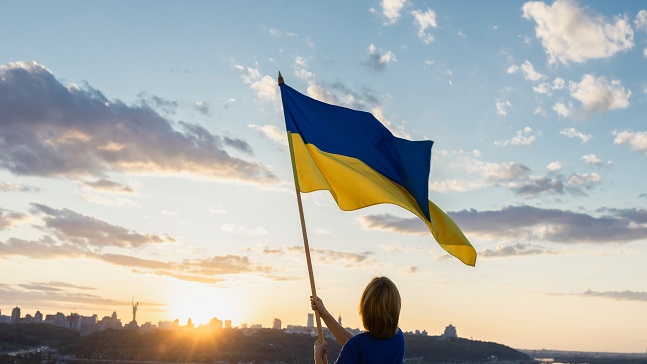 sunsetoverthecityofkyiv-awomanholdsa